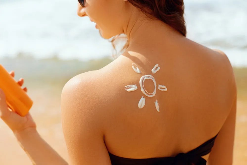 Cover Image for Woman with drawing of the sun with sunscreen