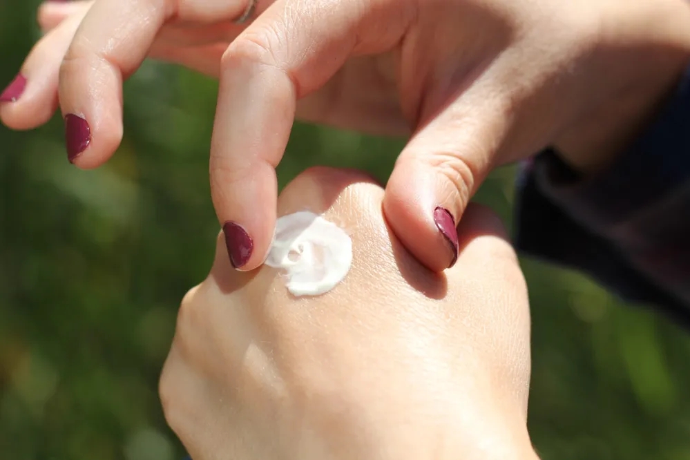 A woman applying cream onto her smooth hands